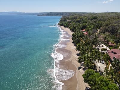 Lush Tropical Beach Paradise with blue water, great waves and rock formations in Montezuma Nicoya Peninsula Costa Rica
