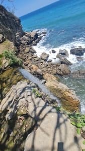 Waterfall into the ocean in a rock formations in Montezuma Nicoya Peninsula Costa Rica