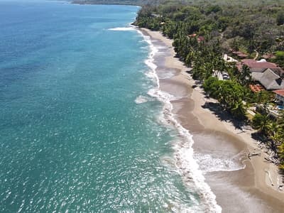 Lush Tropical Beach Paradise with blue water, great waves and rock formations in Montezuma Nicoya Peninsula Costa Rica